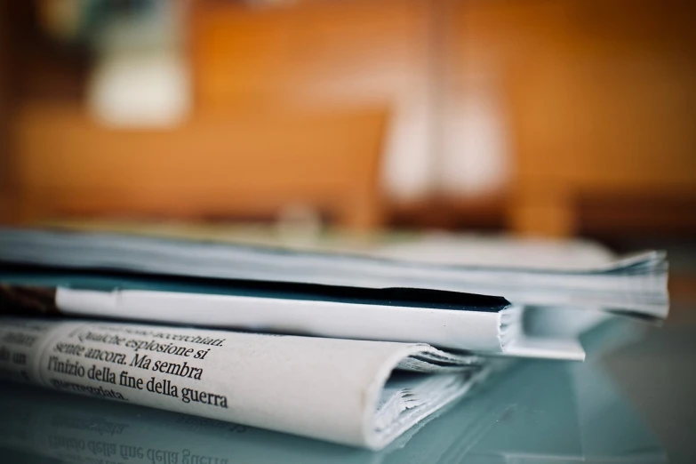 a stack of newspapers sitting on top of a table, a picture, by Matija Jama, macro focus, video, blog-photo, gazeta