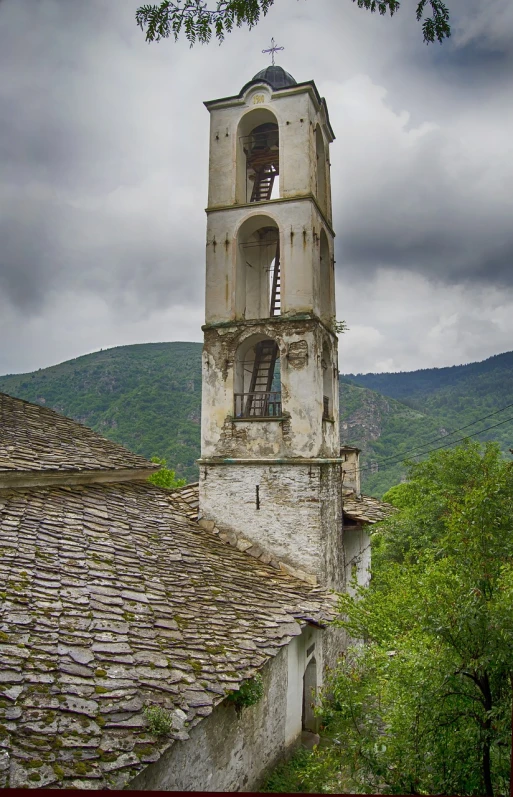 a tall tower with a clock on top of it, a photo, inspired by Hristofor Žefarović, shutterstock, romanesque, abandoned japaense village, bells, on a cloudy day, greece