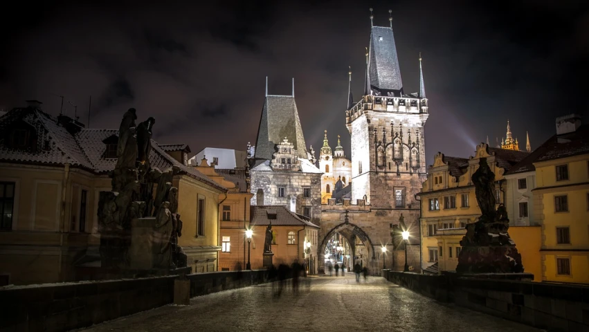 a clock tower towering over a city at night, a picture, by Josef Šíma, old bridge, buildings carved out of stone, inspiring gothic architecture, photo taken in 2018