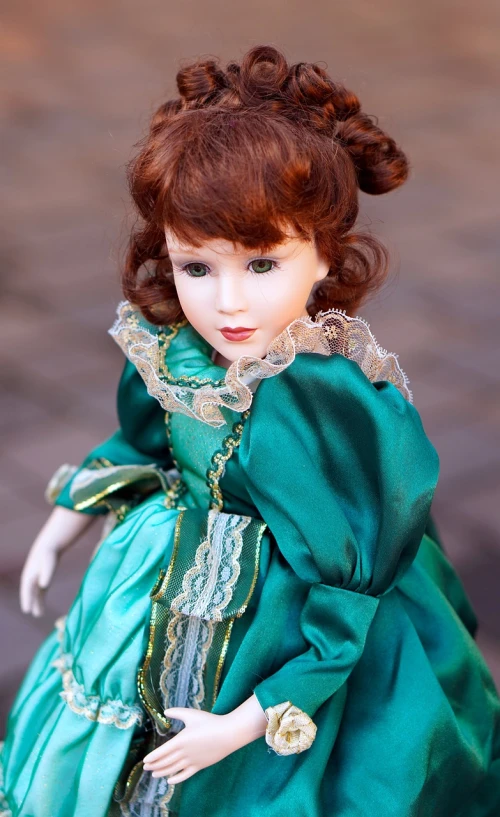 a close up of a doll wearing a green dress, inspired by Margaret Brundage, trending on pixabay, baroque, young redhead girl in motion, innocent look. rich vivid colors, detailed image, on the sidewalk