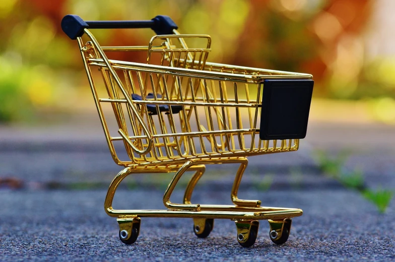 a miniature shopping cart sitting on the pavement, pixabay, modernism, shiny golden, avatar image, clothing drop, side-view