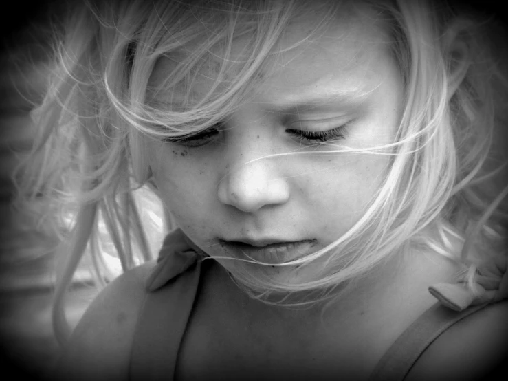 a black and white photo of a little girl, inspired by Max Dupain, pexels, process art, blonde girl, melancholic face, wind, tired face