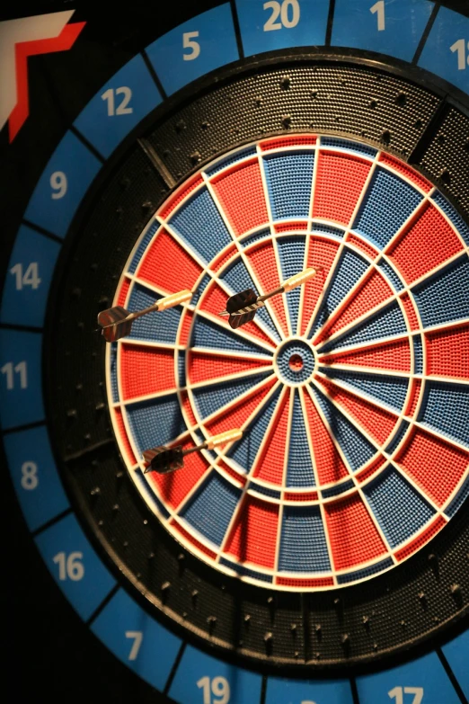 a close up of a dart in the center of a dart board, by Scott M. Fischer, precisionism, photograph credit: ap, red and blue color scheme, dials, devils