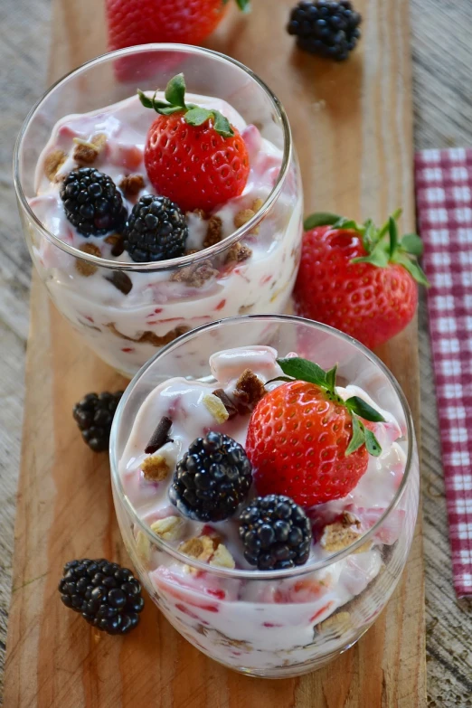 two glasses of fruit and yogurt on a cutting board, by Franz Hegi, pixabay, sea of parfait, black forest, berries inside structure, tocchini