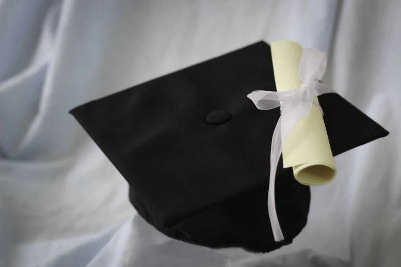 a black graduation cap with a white ribbon, a picture, by Dietmar Damerau, academic art, not blurry, paper, seams, a brightly colored