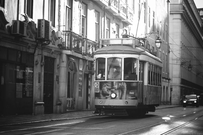 a black and white photo of a trolley going down the street, by Nadir Afonso, flickr, 🦩🪐🐞👩🏻🦳, summer light, in a city with a rich history, 2 0 0 2 photo