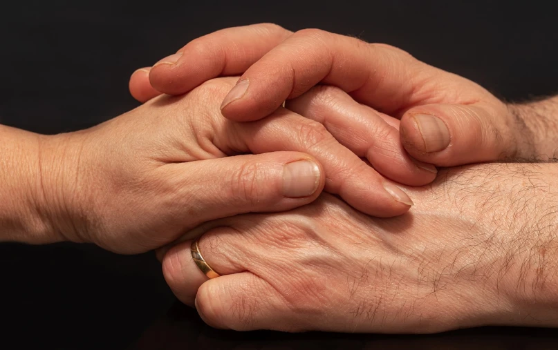 a close up of a person holding a persons hand, a stock photo, by Kazimierz Wojniakowski, shutterstock, romanticism, on black background, repairing the other one, hugging each other, medical photography