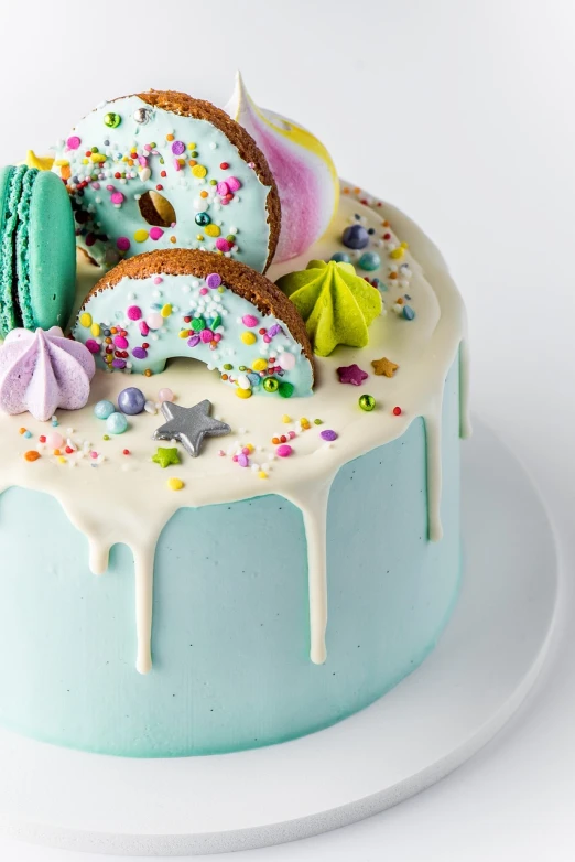 a cake sitting on top of a white plate, a pastel, inspired by Joris van der Haagen, tumblr, unicorns, blender donut, blue and green color scheme, macaron