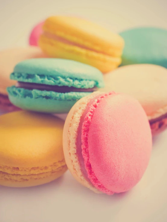 a pile of macarons sitting on top of a white table, a pastel, by Jan Kupecký, shutterstock, romanticism, retro effect, close-up photo, product introduction photo, colorful”