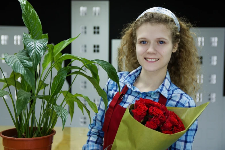 a young girl holding a bouquet of red roses, a stock photo, by Aleksandr Gerasimov, shutterstock, flower shop scene, wearing an apron, product introduction photo