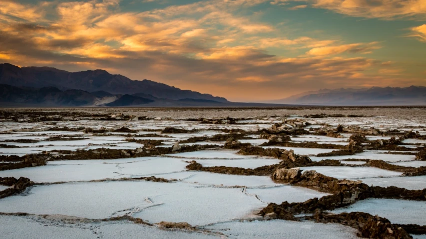 the badlands in death valley national park, death valley national park, death valley national park, death valley national park, death valley national park, by Thomas Carr, shutterstock, romanticism, lake filed with molten gold, cold sunset, white desert, landscape wide shot