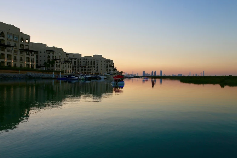 a couple of boats that are in the water, a picture, by Ahmed Karahisari, shutterstock, vista of a city at sunset, lagoon, ameera al taweel, afternoon hangout