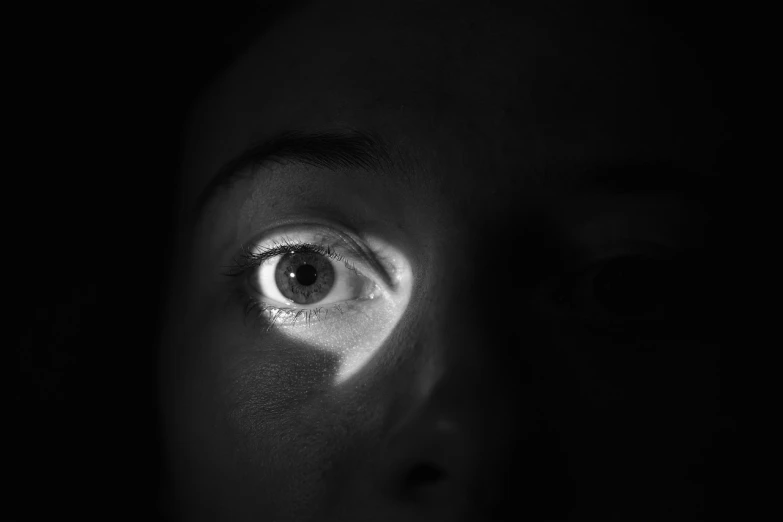a close up of a person's eye in the dark, a black and white photo, female image in shadow, difraction from back light, girl with white eyes, night photo