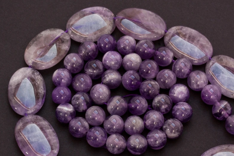 a bunch of purple beads sitting on top of a table, by Ann Thetis Blacker, purple crystal inlays, magnificent oval face, productphoto, 24 35 mm
