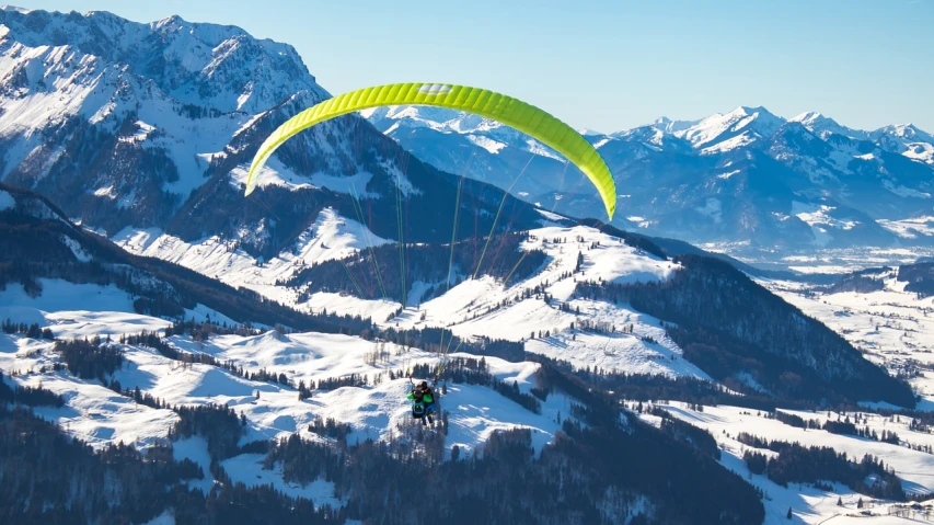 a person paragliding in the mountains on a sunny day, a picture, by Thomas Häfner, shutterstock, figuration libre, winter, aurora green, high quality details, 1128x191 resolution