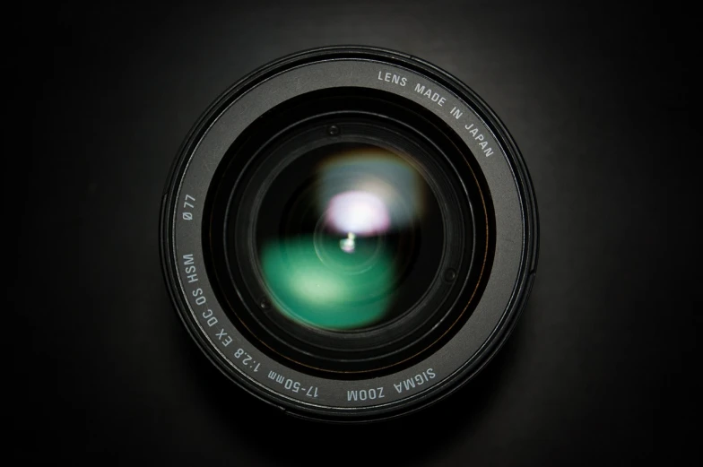 a close up of a camera lens on a black surface, a picture, by Matthias Stom, unsplash, art photography, 4 5 mm. photorealistic, soft lens, sigma 2 4 mm, with wide angle lens