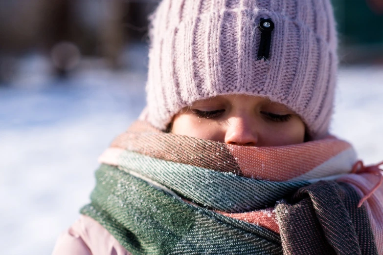 a close up of a person wearing a hat and scarf, by Emma Andijewska, pexels, tiny girl looking on, freezing, 1 2 9 7, bottom angle