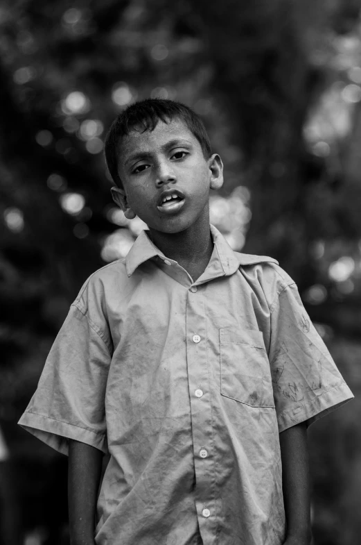 a black and white photo of a young boy, a black and white photo, by Ibrahim Kodra, sri lanka, portrait shot 8 k, 38mm photograhpy, black & white photograph