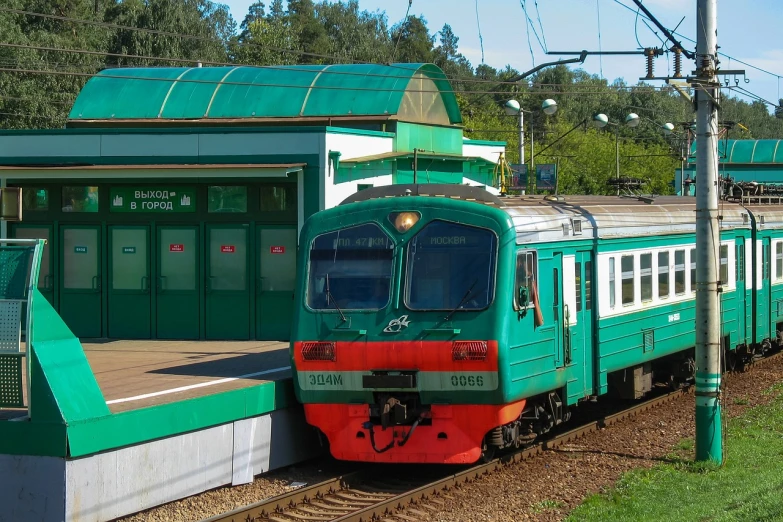 a green train pulling into a train station, a portrait, by Pavel Fedotov, shutterstock, regionalism, kashin, front view 2 0 0 0, sbt, lozhkin