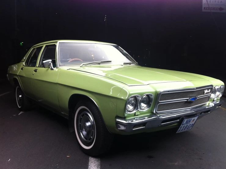 a green car is parked in a parking lot, a pastel, by Brigette Barrager, flickr, cobra, melbourne, pale green backlit glow, 70s design, patriot