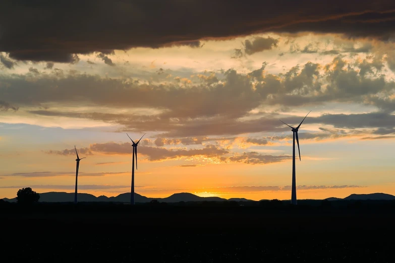 a group of wind turbines sitting on top of a field, a picture, fine art, beautiful new mexico sunset, usa-sep 20, low ultrawide shot, moody sunset