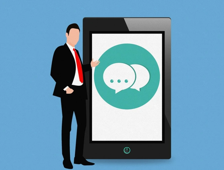 a man in a suit standing next to a tablet with a speech bubble on the screen, by Matija Jama, trending on pixabay, tachisme, corporate phone app icon, 2 people, older male, over-shoulder shot