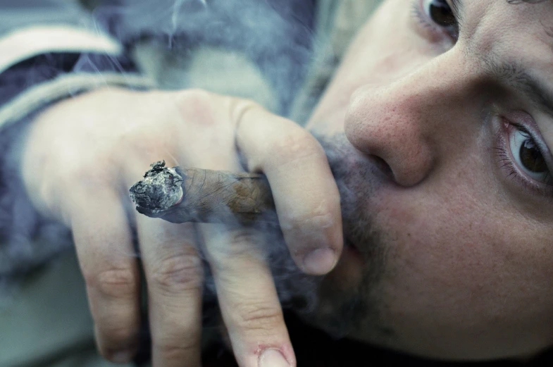 a close up of a person smoking a cigarette, a portrait, by Paul Davis, renaissance, marijuana photography, istockphoto, atmospheric ”, smoking a big cigar