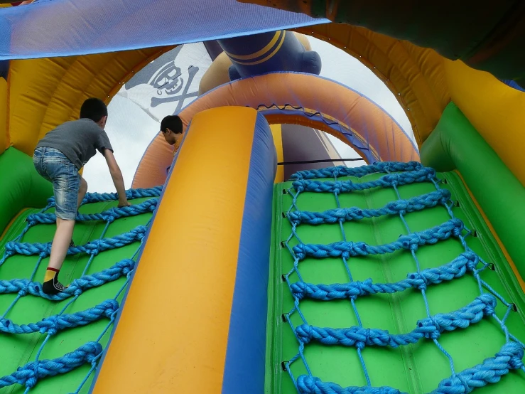 a young boy playing on an inflatable slide, a photo, by Edward Corbett, shutterstock, pirates, screen cap, installation, really close - up shot