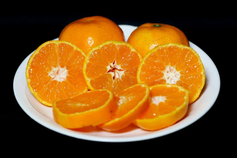 a white plate topped with sliced oranges on top of a table, by Jan Rustem, high quality photos, colors orange, excellent detail, ready to eat