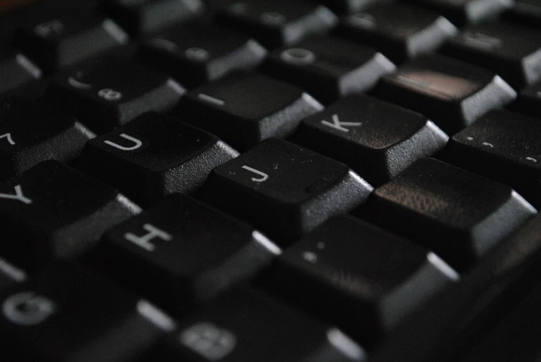 a close up of a black computer keyboard, a screenshot, unsplash, wikimedia commons, shot from a low angle, computers, cyberpunc