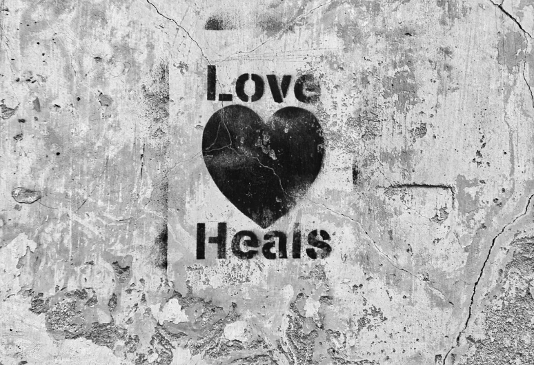 a black and white photo of a heart on a wall, an album cover, by Lucia Peka, pexels, graffiti, healer, holistic medicine advertisement, knee, with text