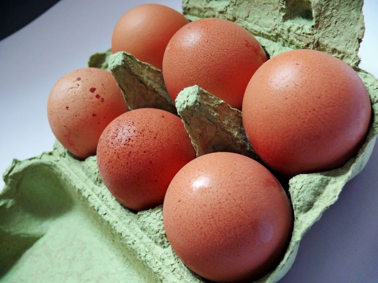 a carton filled with eggs sitting on top of a table, a pastel, by Stefan Gierowski, flickr, some red, 6 pack, bumpy skin, cut-away