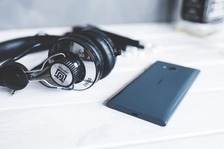 a cell phone sitting next to a pair of headphones, a picture, pexels, bauhaus, sony a 7 s, soundwave, rich details, wallpaper 4k