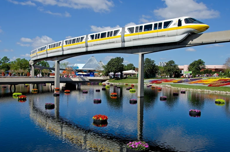 a train traveling over a bridge over a body of water, a picture, by Ken Elias, flickr, visual art, epcot, white and yellow scheme, hanging gardens, 1 0 0 m