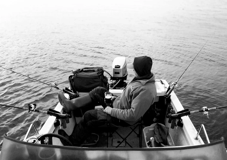 a man sitting in a boat with a fishing rod, a black and white photo, by Jaakko Mattila, unsplash, casey cooke, warm spring, many details, instagram picture