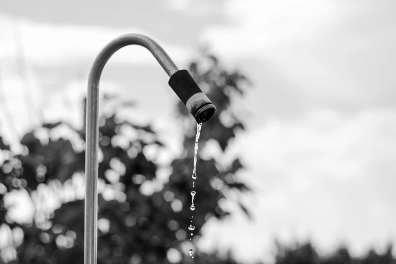 a black and white photo of a water faucet, a black and white photo, scorching weather, 8k 50mm iso 10, unhappy, outdoor photo