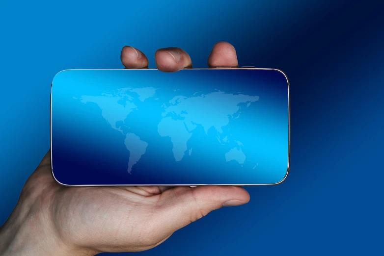 a person holding a cell phone with a world map on it, a hologram, by Jon Coffelt, pixabay, stock photo, solid blue background, glass reflections on top, mouse photo