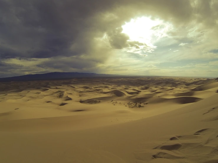 the sun shines through the clouds over the sand dunes, baroque, tengri, gopro shot of the hell, wide shot photo