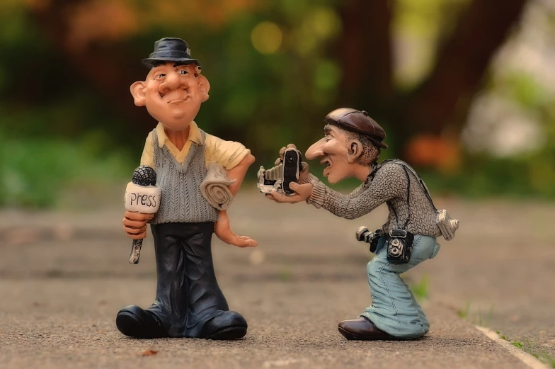 a figurine of a man taking a picture of another man, pixabay contest winner, figurativism, caricaturist, giving an interview, cute decapodiformes, newspaper photography