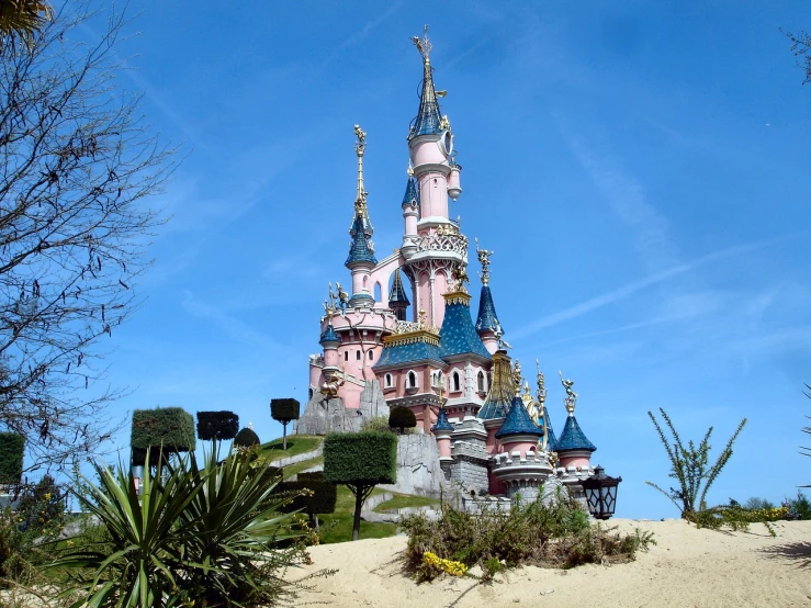 a pink castle sitting on top of a sandy hill, by Walt Disney, flickr, ornate french architecture, detailed high resolution, moss, typical