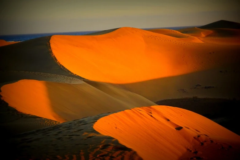 a person riding a horse in the desert, a tilt shift photo, by Etienne Delessert, shadows. asian landscape, orange glow, dune, red!! sand