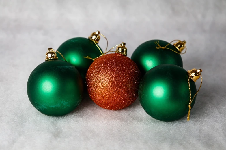 a group of green and gold christmas ornaments, a photo, by Juan O'Gorman, bright green dark orange, still life with snow, high quality product photo, closeup photo