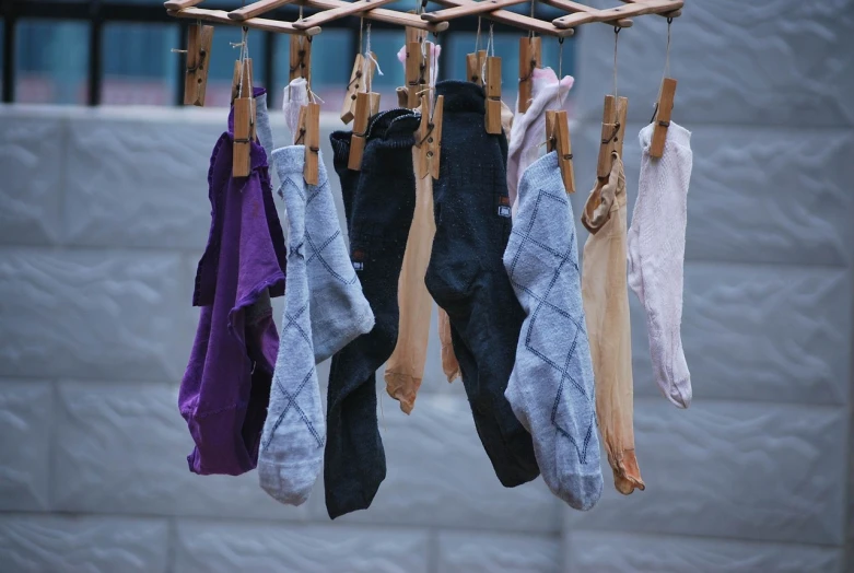 a bunch of socks hanging on a clothes line, by Magdalene Bärens, renaissance, moisture, purple bridges with leggins, a wooden, photograph credit: ap