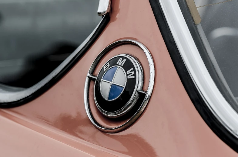 a close up of a bmw emblem on a car, a colorized photo, by Hans Schwarz, unsplash, synthetism, peach embellishment, highly detailed rounded forms, 1 9 6 3, best on adobe stock
