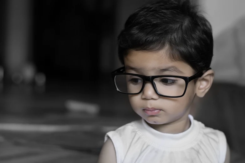 a close up of a child wearing glasses, a picture, pexels, bangalore, depressed sad expression, shot with canon 5 d mark ii, young cute wan asian face