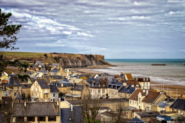 a group of houses sitting on top of a hill next to the ocean, a tilt shift photo, by Etienne Delessert, art nouveau, normandy, hdr photo, in the foreground a small town, stock photo