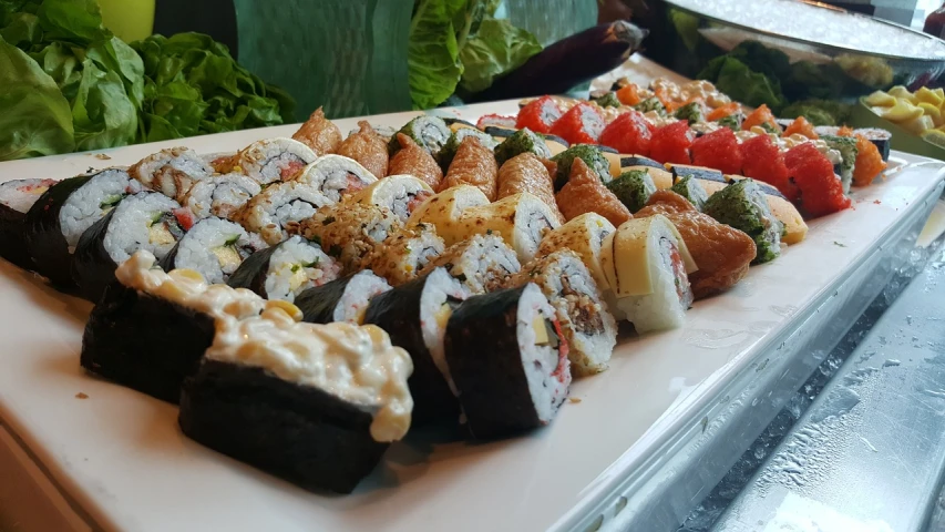 a table topped with lots of different types of sushi, a picture, by Tom Wänerstrand, hurufiyya, dramatic angle, on a bright day, 3/4 side view, shiny and sparkling