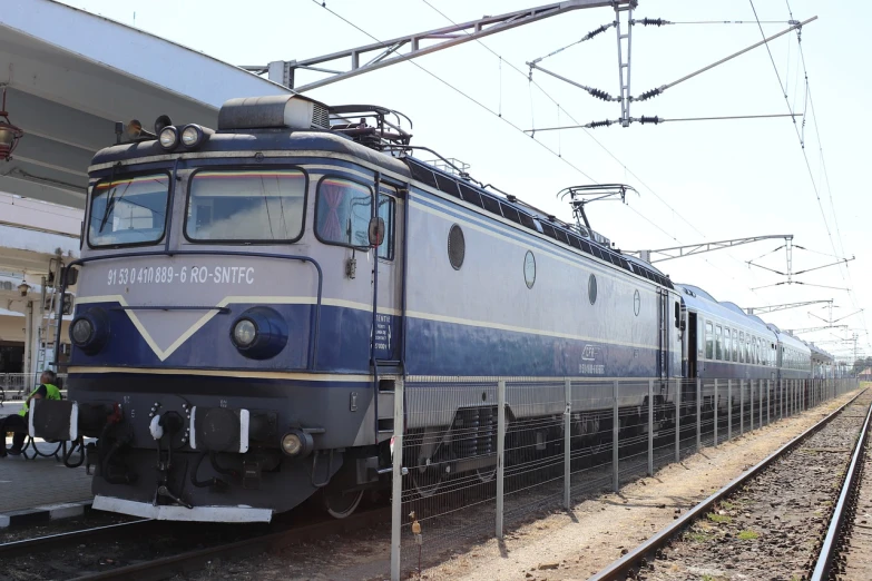 a blue and white train pulling into a train station, shutterstock, diesel engine, hungarian, spherical, 4 0 9 6