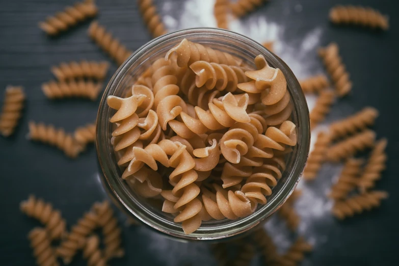 a glass bowl filled with pasta on top of a table, a macro photograph, corduroy, made of food, without duplication, dark filaments