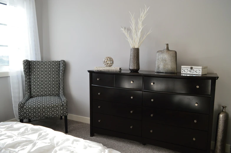 a black dresser sitting in a bedroom next to a window, by Joy Garnett, unsplash, visual art, armchairs, serene and peaceful style, silver accessories, great details